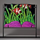 Stained glass clownfish amid green seaweed and coral