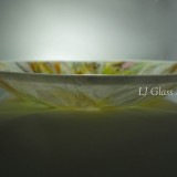 Shallow marbled glass bowl on gray background
