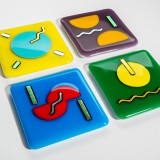Four colorful abstract glass coasters on white